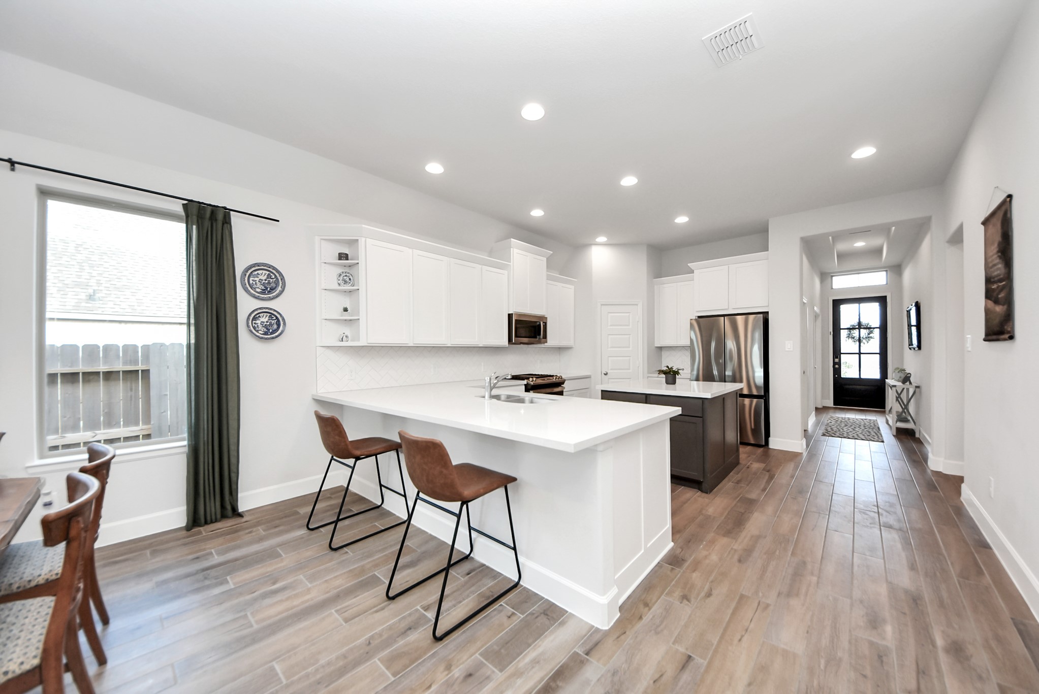 42546 Summer Crst Road Magnolia, TX 77354 - Photo 4 of 27 As you approach your chefs kitchen with separate island, notice the details which feature: wood tile flooring throughout, exposed modern shelving, quartz countertops with herring bone stone tiles and gas stove.