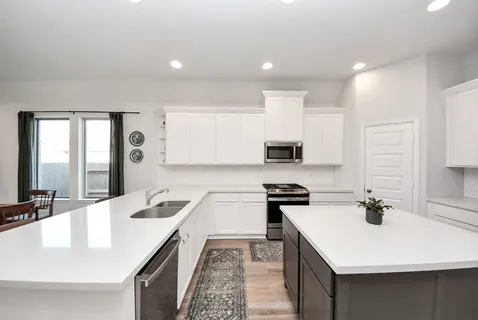a kitchen with a sink a stove and cabinets