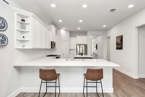 a kitchen with granite countertop a counter space and chairs