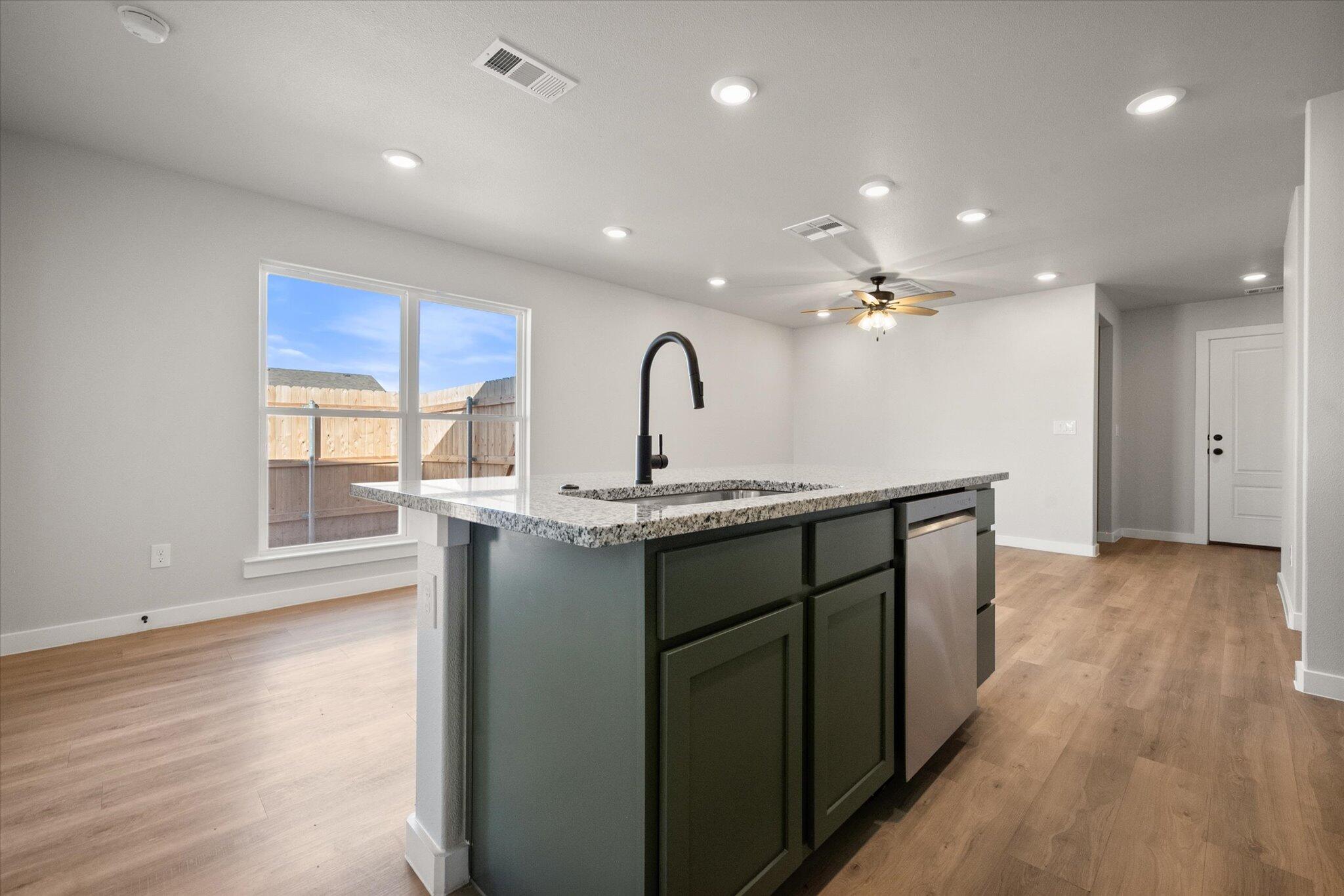 6302 Volney Avenue Lubbock, TX 79407 - Photo 12 of 20 a kitchen with kitchen island granite countertop a sink and wooden cabinets