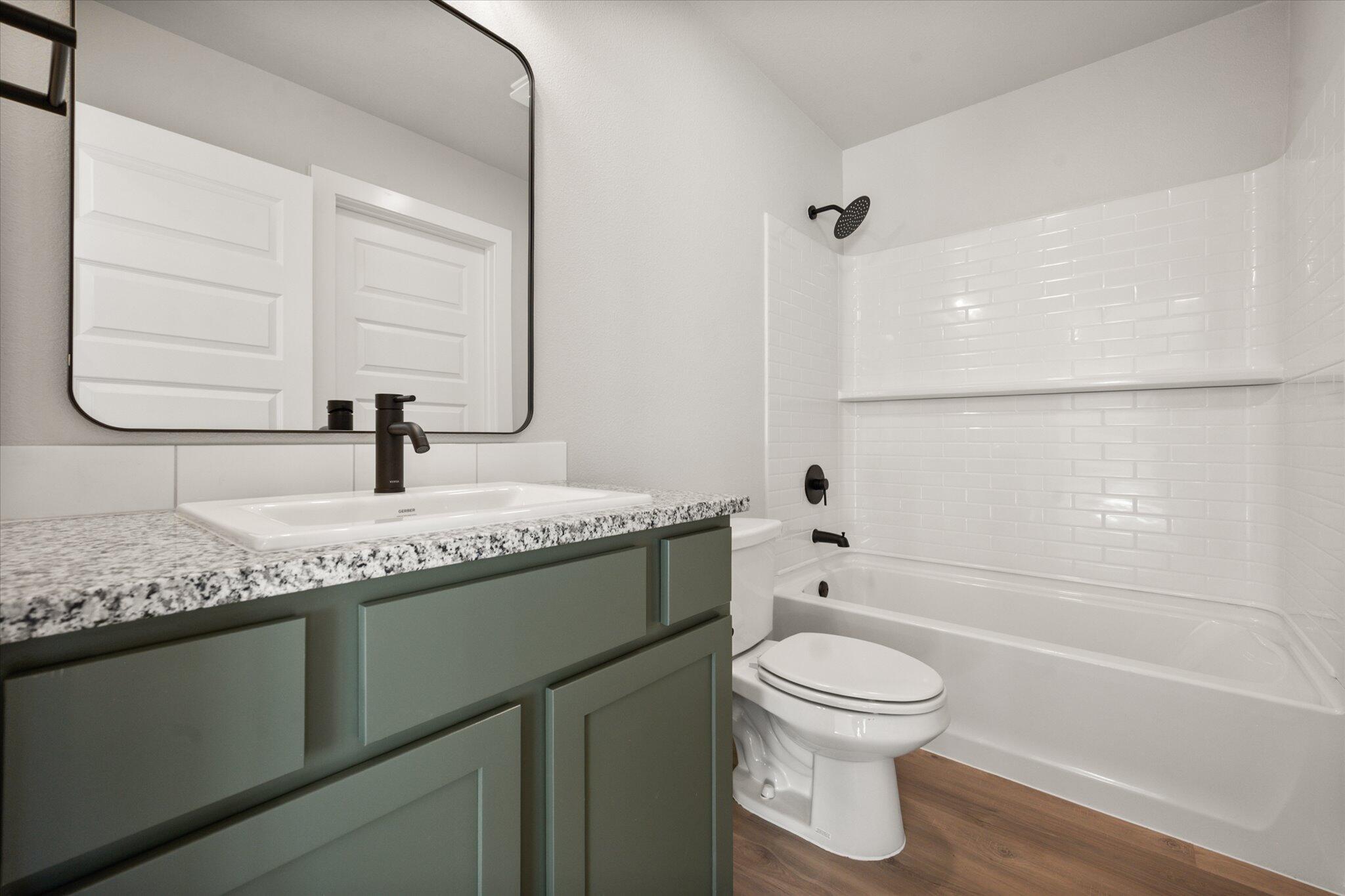 6302 Volney Avenue Lubbock, TX 79407 - Photo 15 of 20 a bathroom with a granite countertop toilet a sink and a bathtub