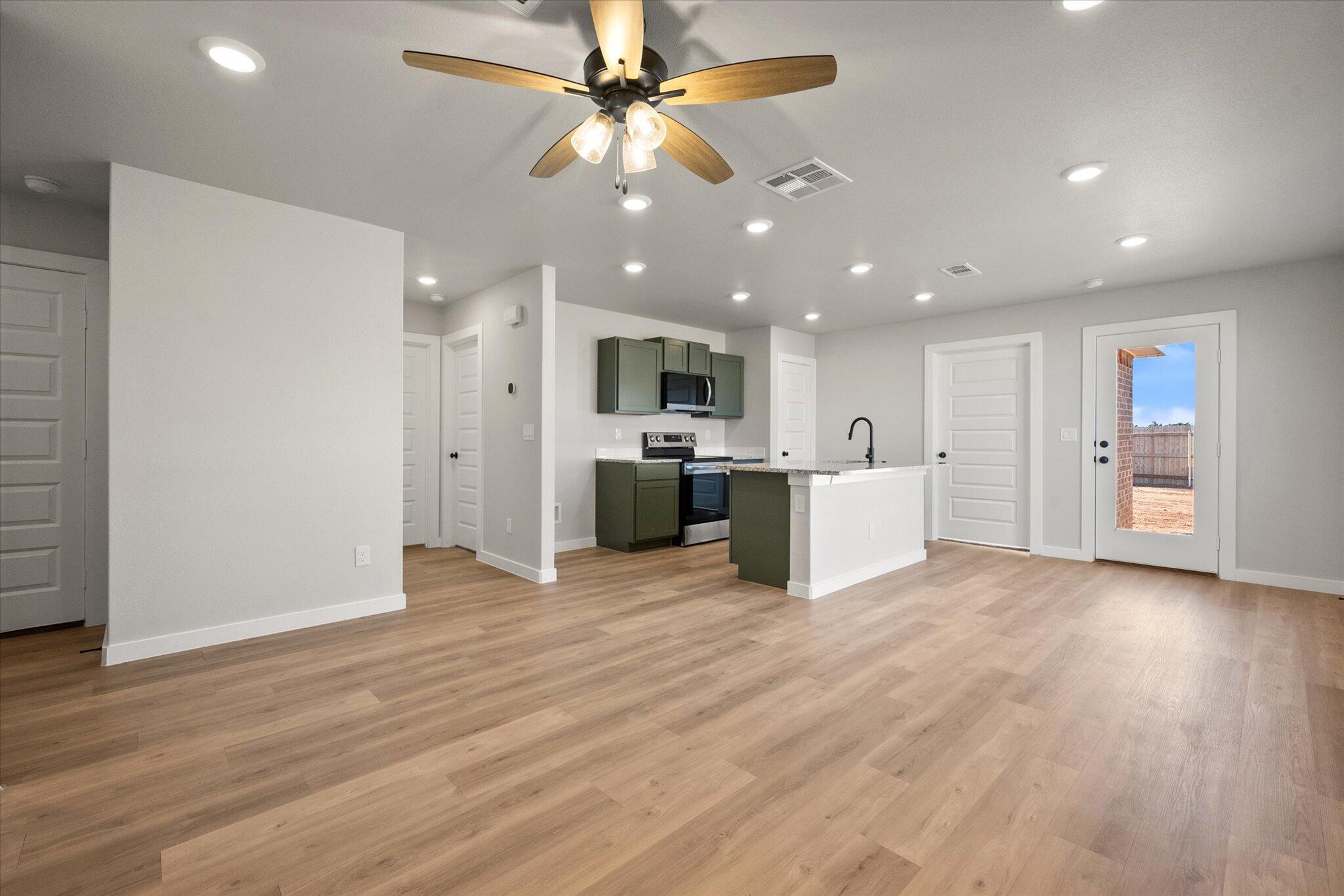 6302 Volney Avenue Lubbock, TX 79407 - Photo 4 of 20 a view of a kitchen with a microwave and a ceiling fan