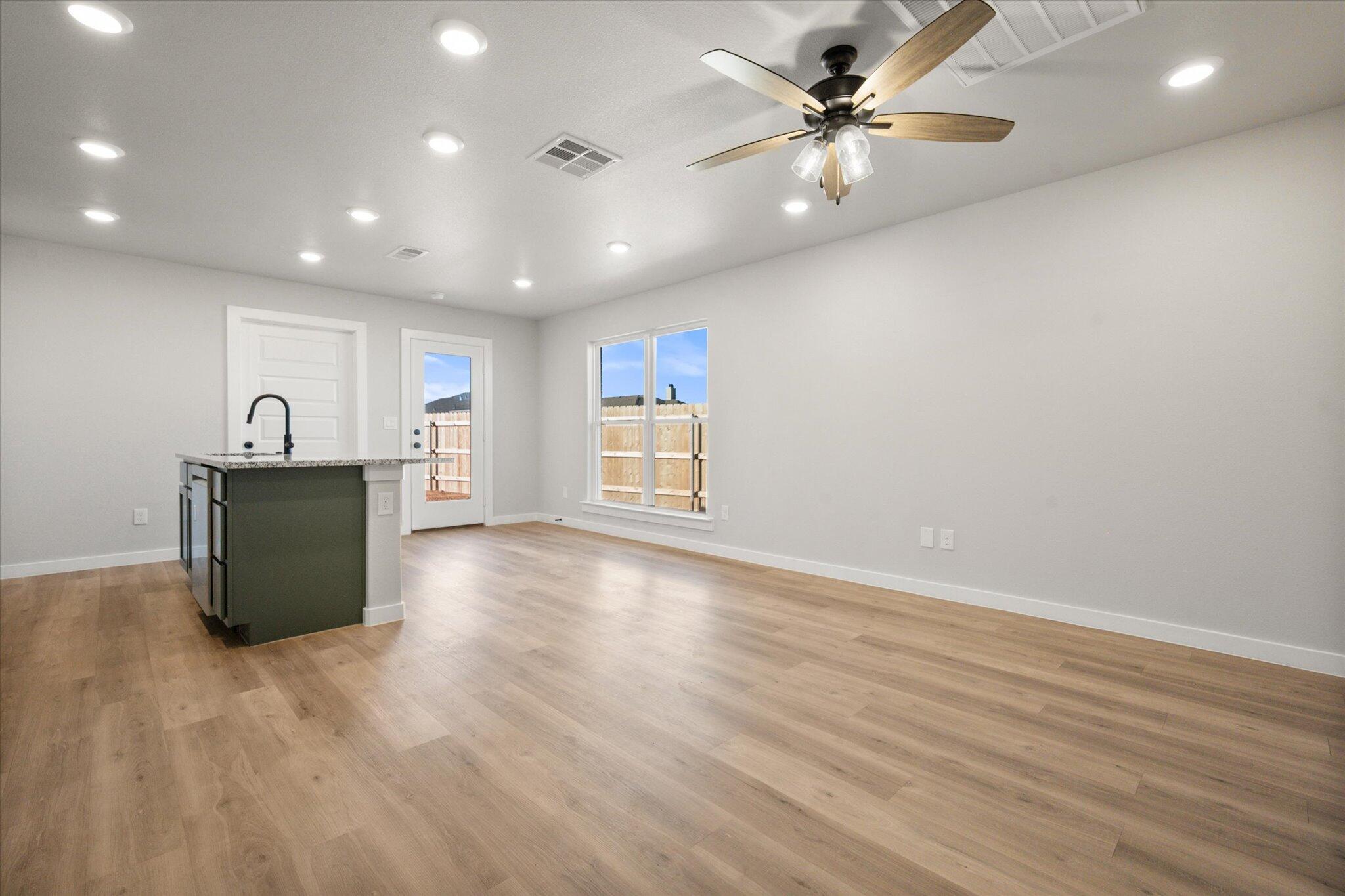 6302 Volney Avenue Lubbock, TX 79407 - Photo 5 of 20 a view of an empty room with a window and wooden floor