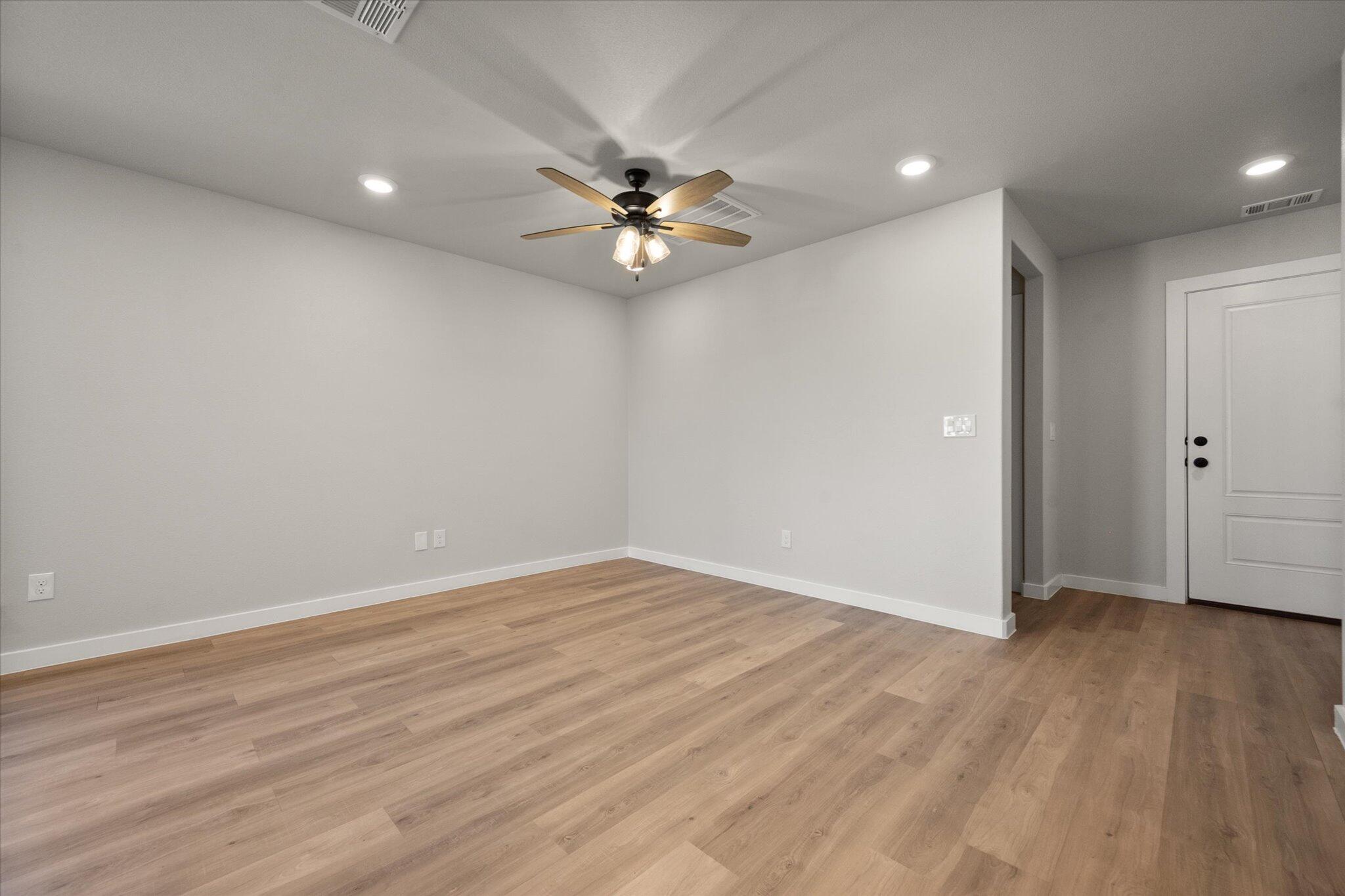 6302 Volney Avenue Lubbock, TX 79407 - Photo 6 of 20 wooden floor in an empty room with a window