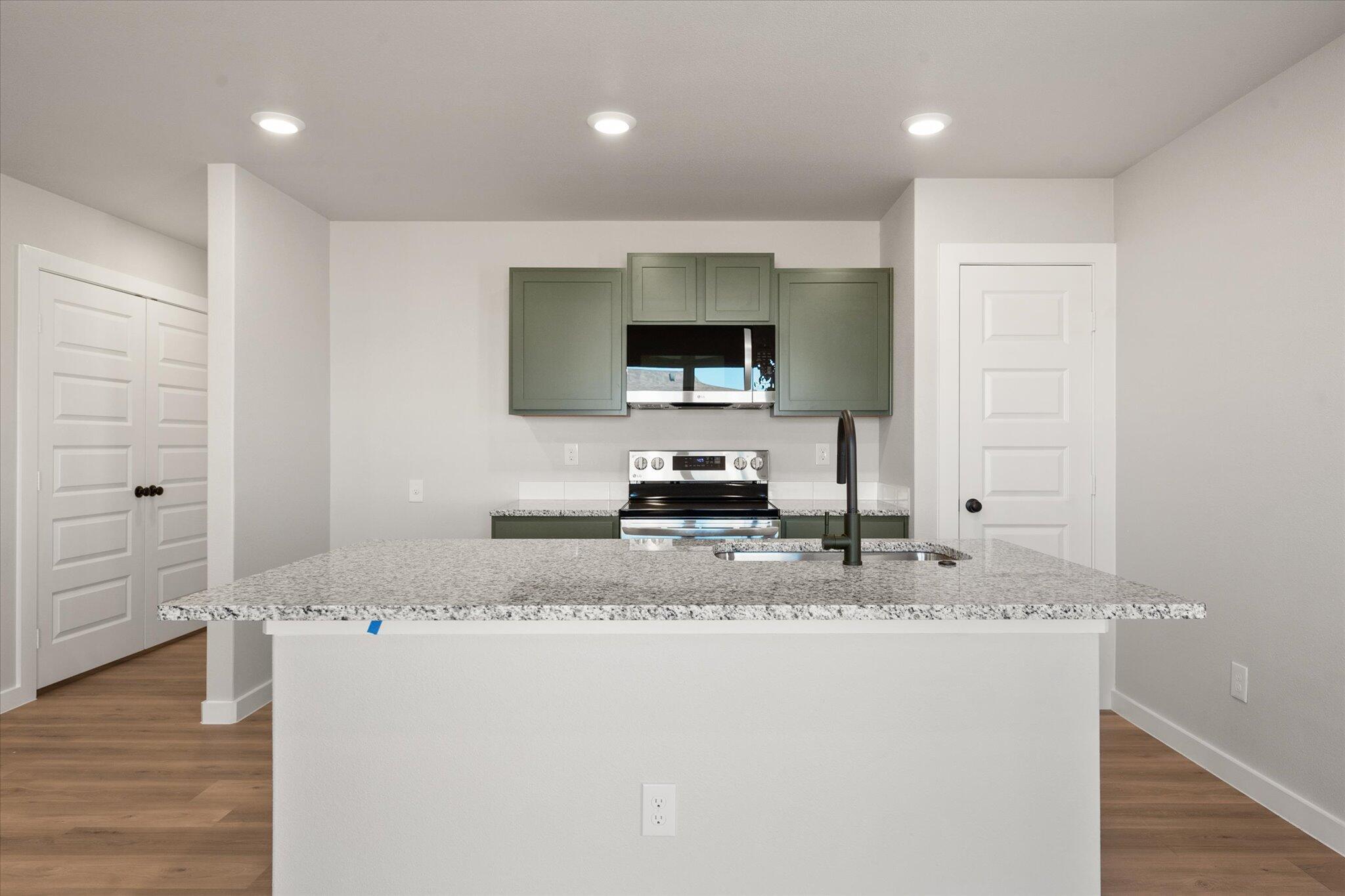 6302 Volney Avenue Lubbock, TX 79407 - Photo 8 of 20 a kitchen with sink refrigerator and microwave