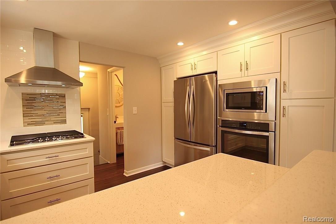 931 West 3rd Street Rochester, MI 48307 - Photo 10 of 62 New kitchen with white, soft close cabinetry, stainless hardware, new stainless counter depth fridge, built-in oven, microwave, dishwasher, gas cooktop and hood, Quartz counters. Bright room with recessed lighting