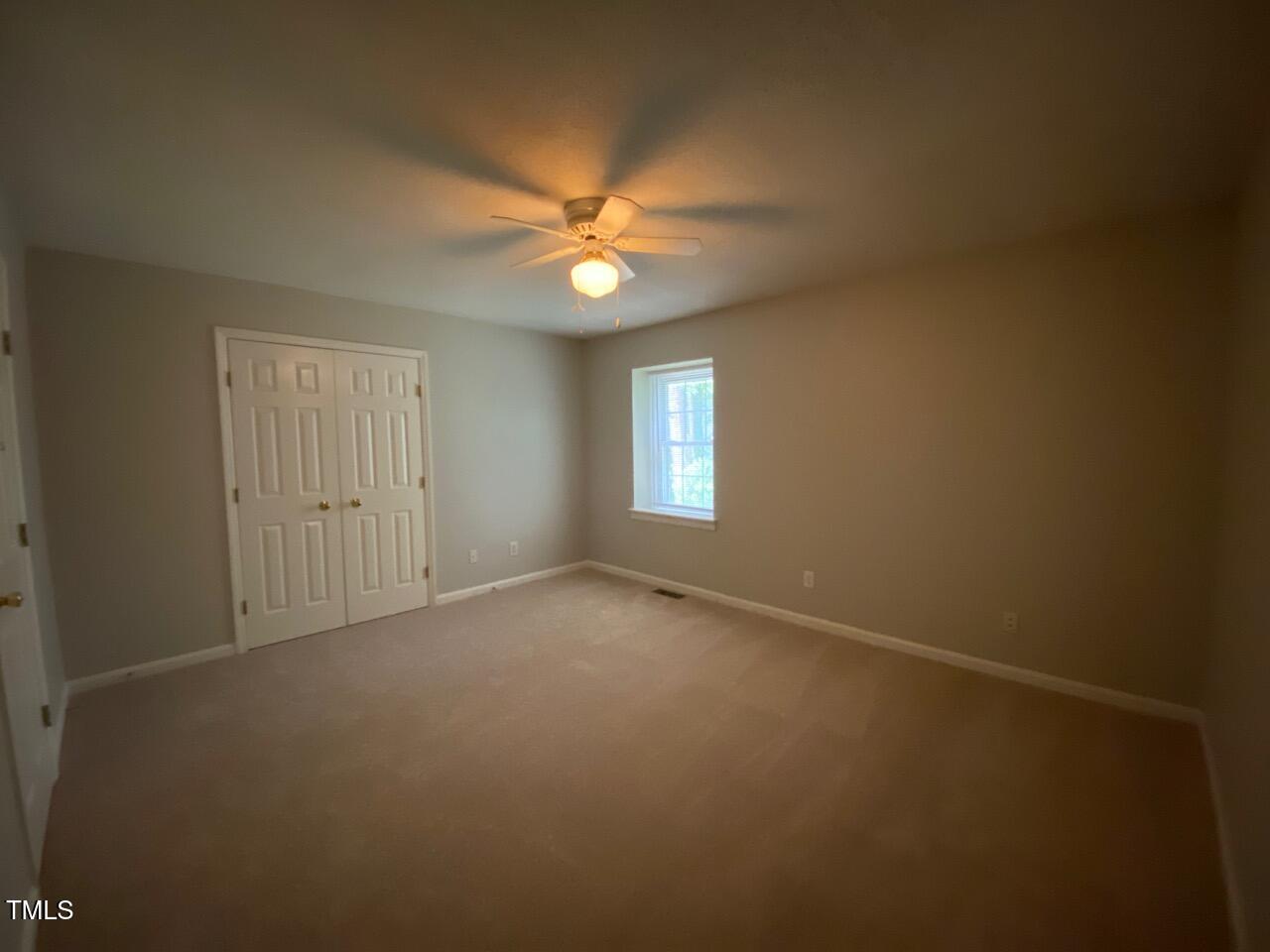 4706 Blue Bird Court, Unit I Raleigh, NC 27606 - Photo 11 of 16 an empty room with windows and fan