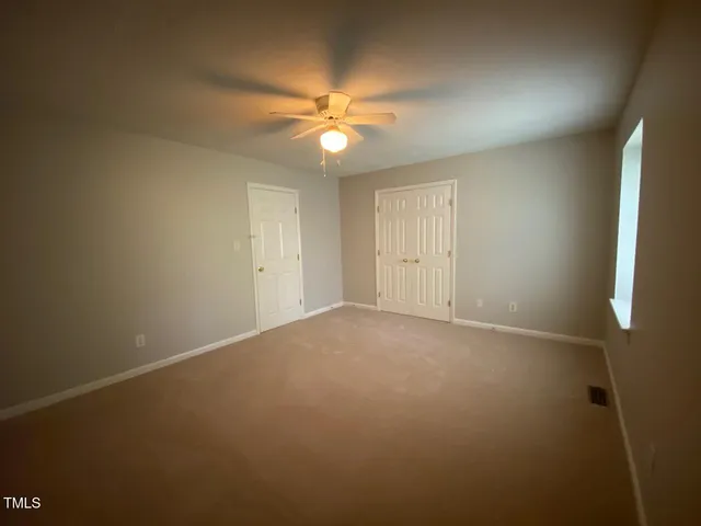 an empty room with a fan and a fan