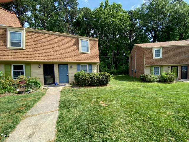 a front view of a house with a yard and trees