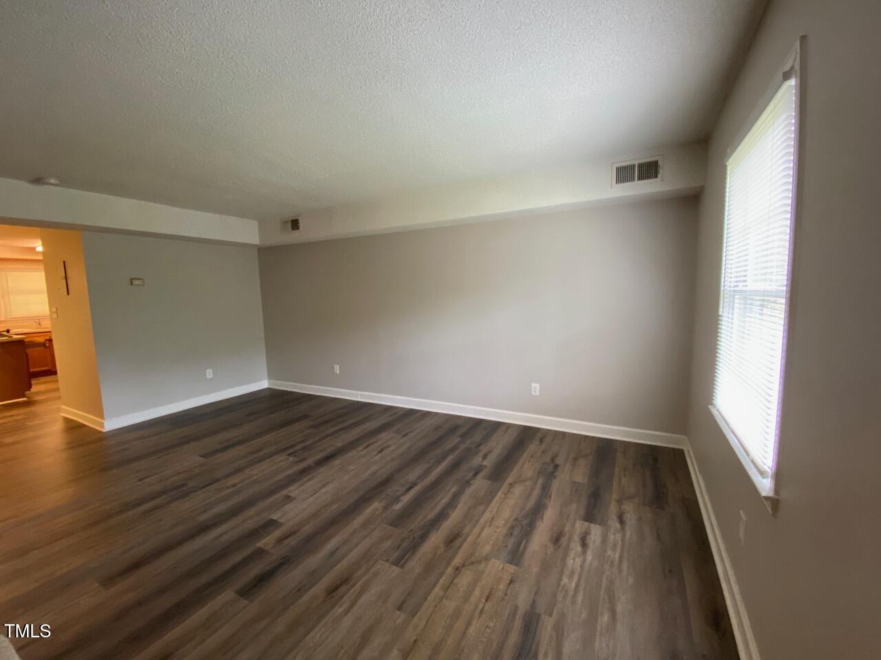 4706 Blue Bird Court, Unit I Raleigh, NC 27606 - Photo 4 of 16 wooden floor in an empty room with a window