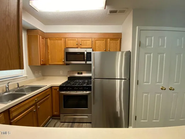 a kitchen with a refrigerator stove and sink