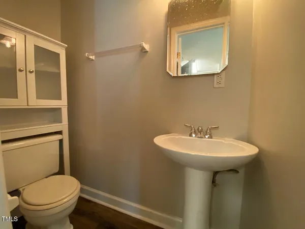 a bathroom with a sink toilet and a mirror