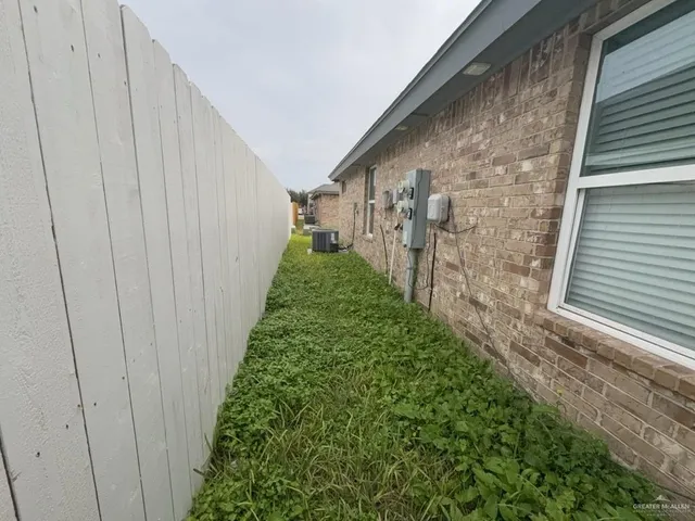 an empty room with wooden floor and ceiling fan