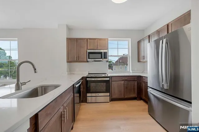 a kitchen with granite countertop a refrigerator and a sink