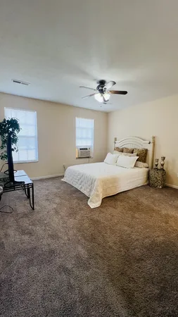 a spacious bedroom with a bed and a table in it