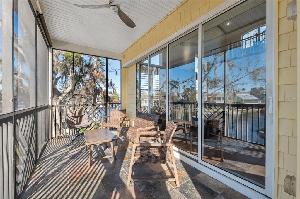 5287 Tuna Lane Weeki Wachee, FL 34607 - Photo 31 of 85 a view of a patio with table and chairs and floor to ceiling window with wooden floor
