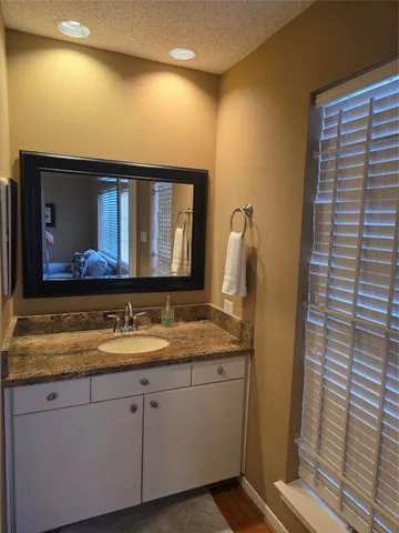 a bathroom with a granite countertop sink and a mirror