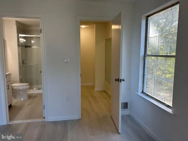 a bathroom with a glass door shower and a toilet