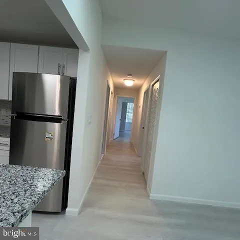 a view of a refrigerator in kitchen and wooden floor