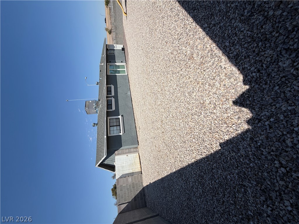 2820 South Sandhill Road, Unit A Las Vegas, NV 89121 - Photo 26 of 26 A gravel-covered lot provides ample exterior space beside the grey-hued structure.
