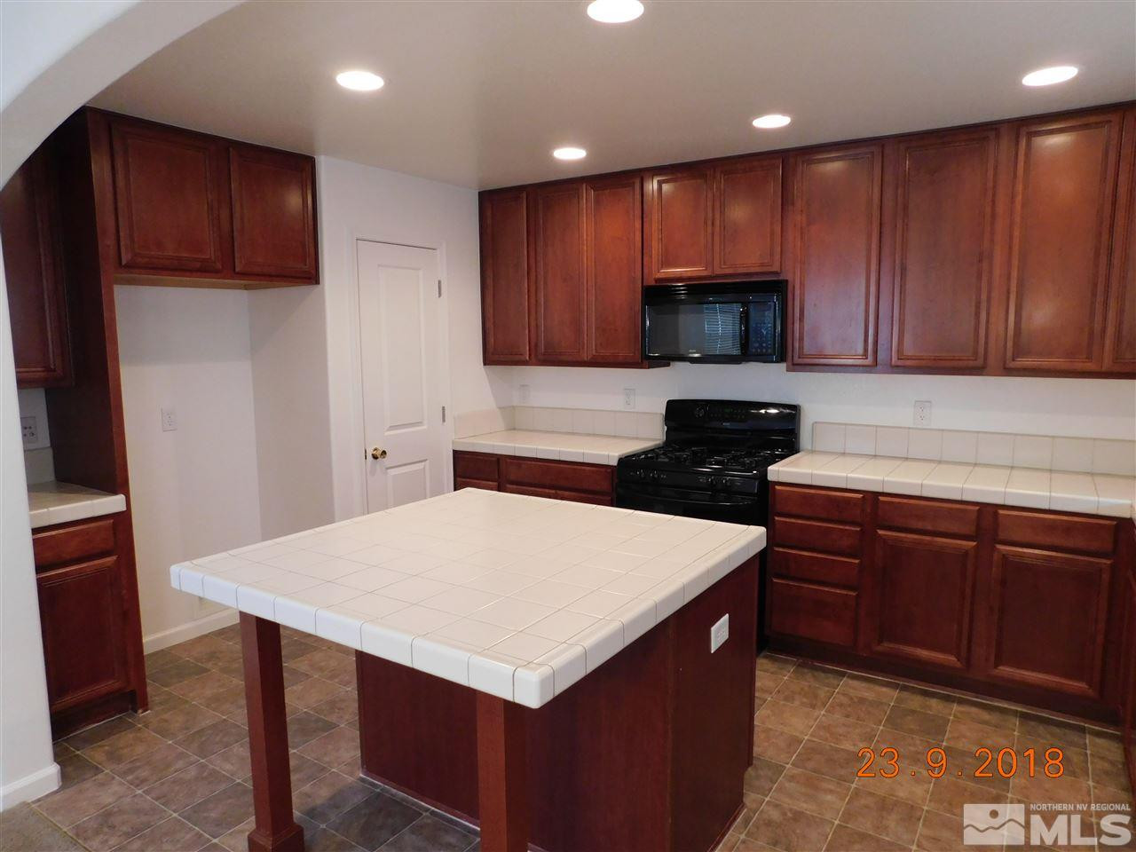 1606 Lone Oak Trail Reno, NV 89523 - Photo 5 of 10 a kitchen with wooden cabinets and refrigerator