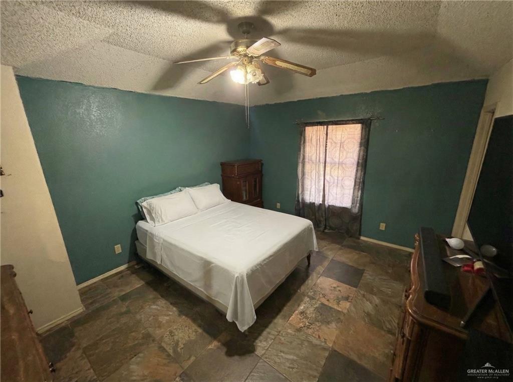 1901 South 34th Street McAllen, TX 78503 - Photo 7 of 13 a spacious bedroom with a bed and a chandelier