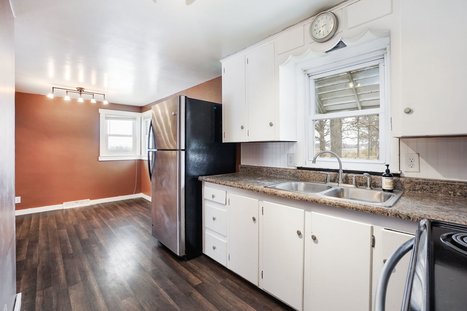 1737 Lee Center Road Amboy, IL 61310 - Photo 9 of 19 a kitchen with granite countertop wooden floors white cabinets and stainless steel appliances
