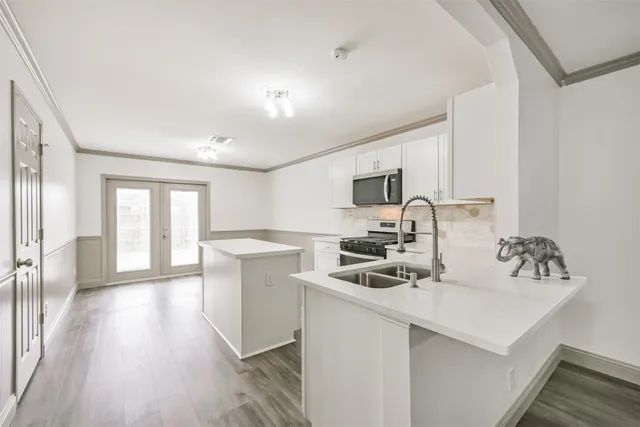 a kitchen with a sink cabinets and wooden floor