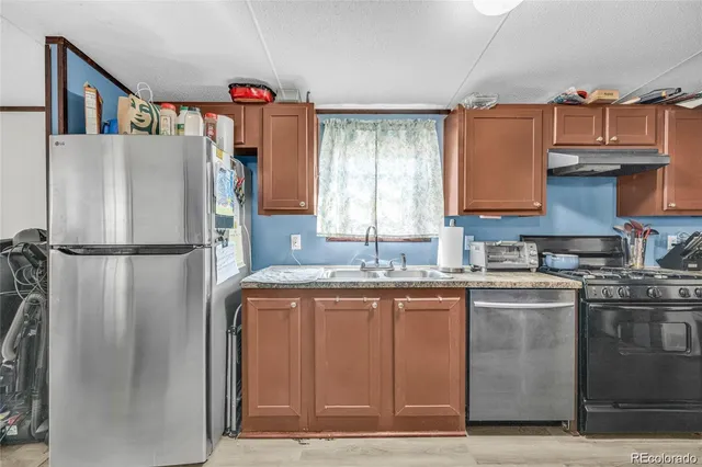 a kitchen with stainless steel appliances granite countertop a refrigerator and a sink