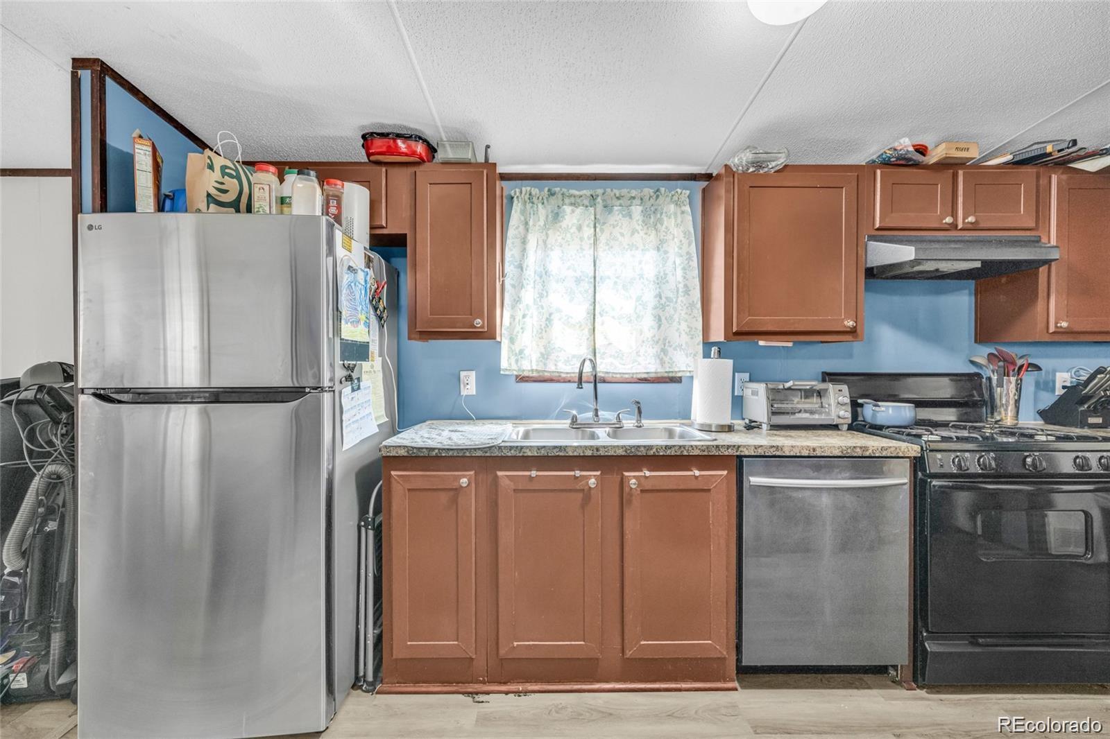 10 Jason Street Castle Rock, CO 80109 - Photo 3 of 11 a kitchen with stainless steel appliances granite countertop a refrigerator and a sink