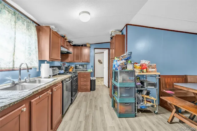 a kitchen with stainless steel appliances granite countertop a refrigerator a sink dishwasher and a stove with wooden floor