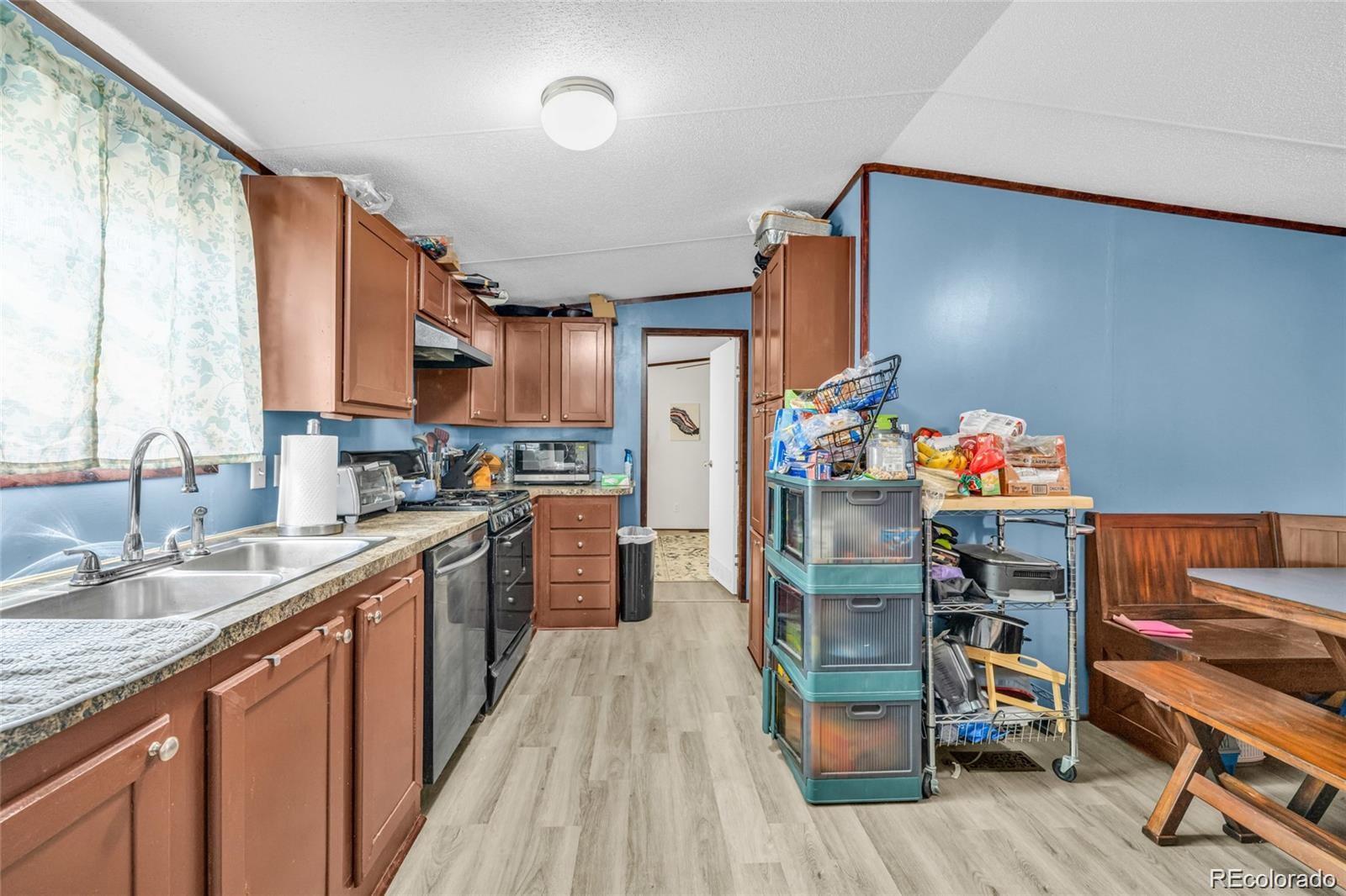 10 Jason Street Castle Rock, CO 80109 - Photo 4 of 11 a kitchen with stainless steel appliances granite countertop a refrigerator a sink dishwasher and a stove with wooden floor