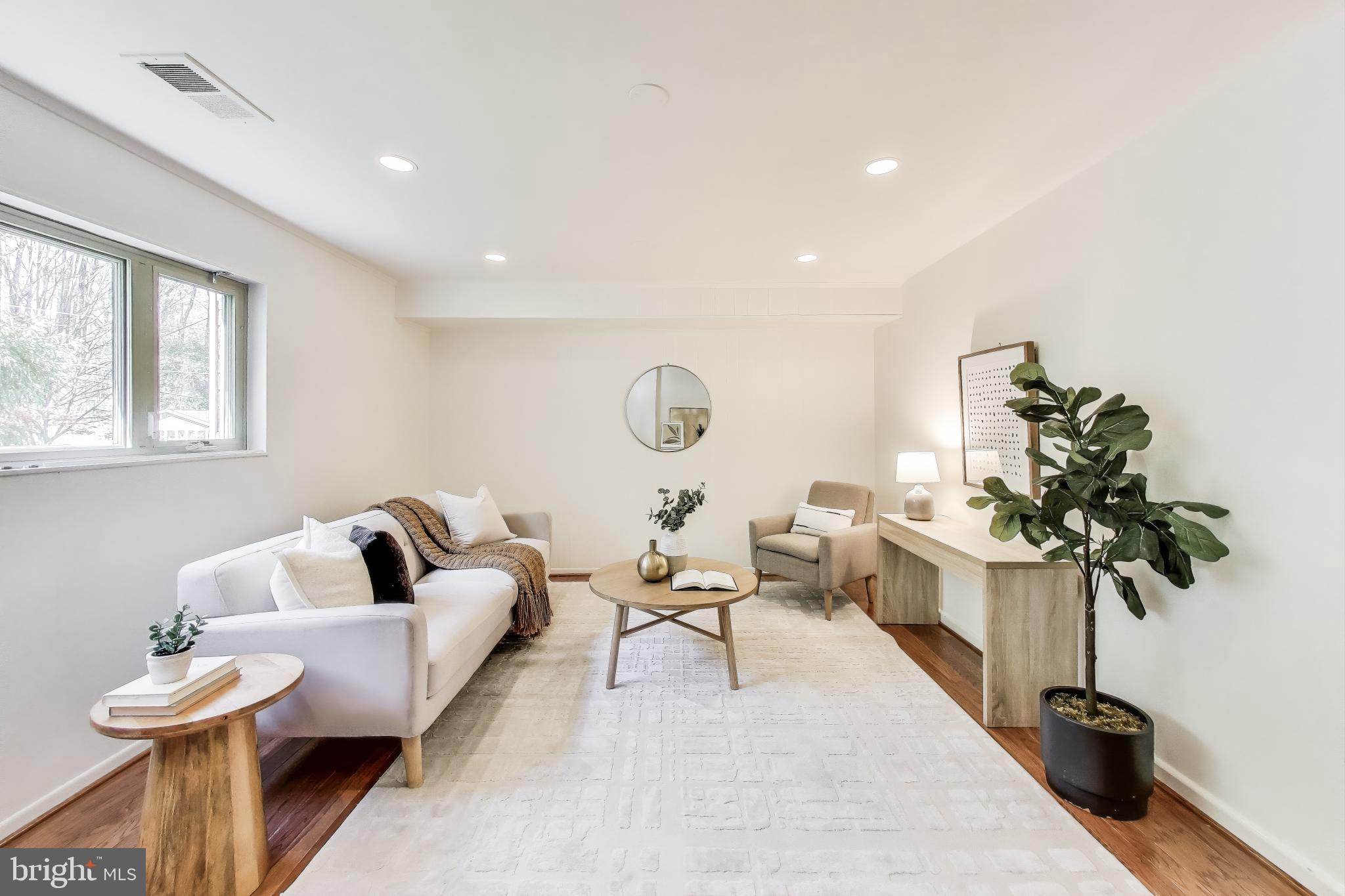 8905 Spring Valley Road Chevy Chase, MD 20815 - Photo 23 of 42 a living room with furniture a chandelier and a potted plant