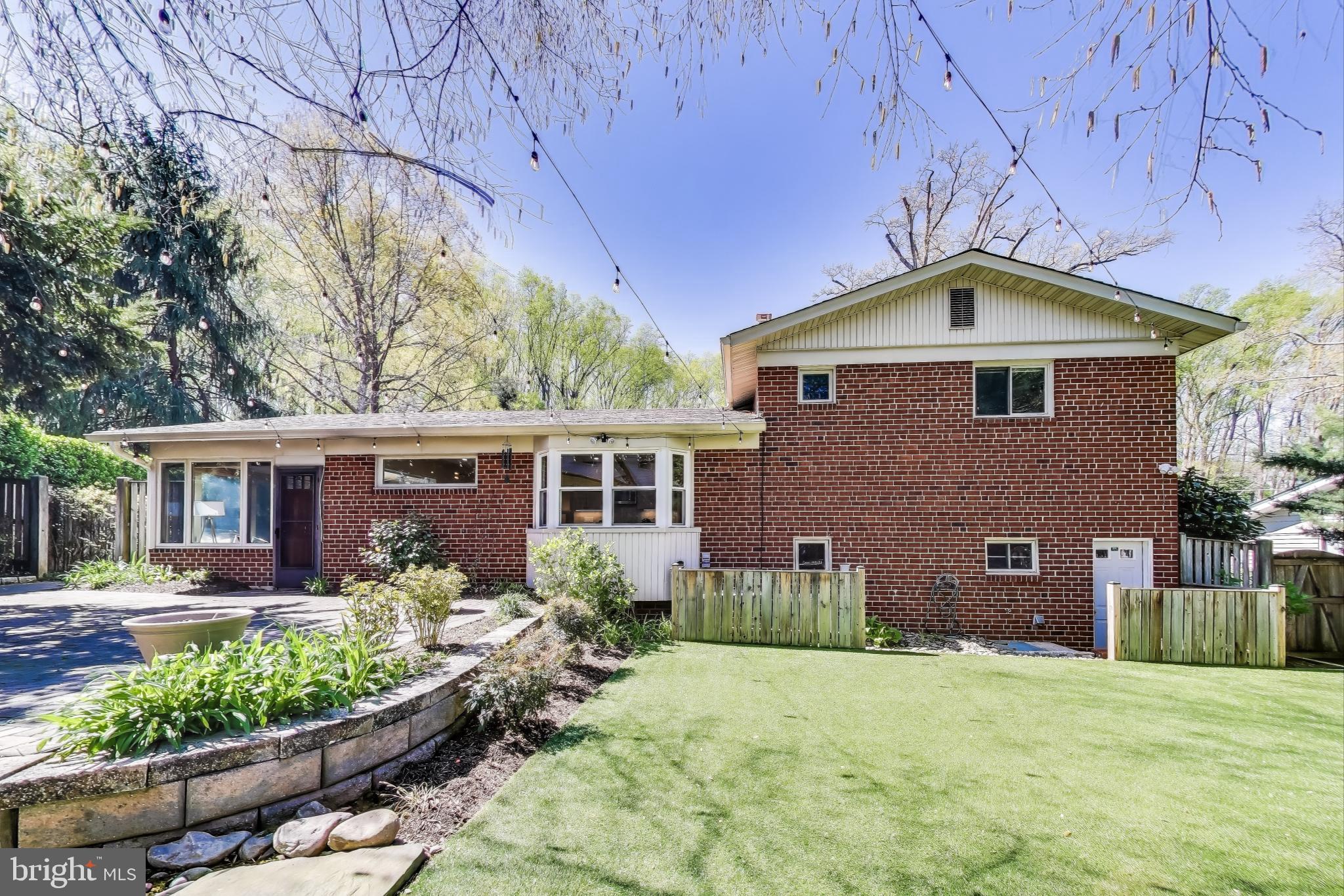 8905 Spring Valley Road Chevy Chase, MD 20815 - Photo 31 of 42 a front view of a house with a yard and potted plants