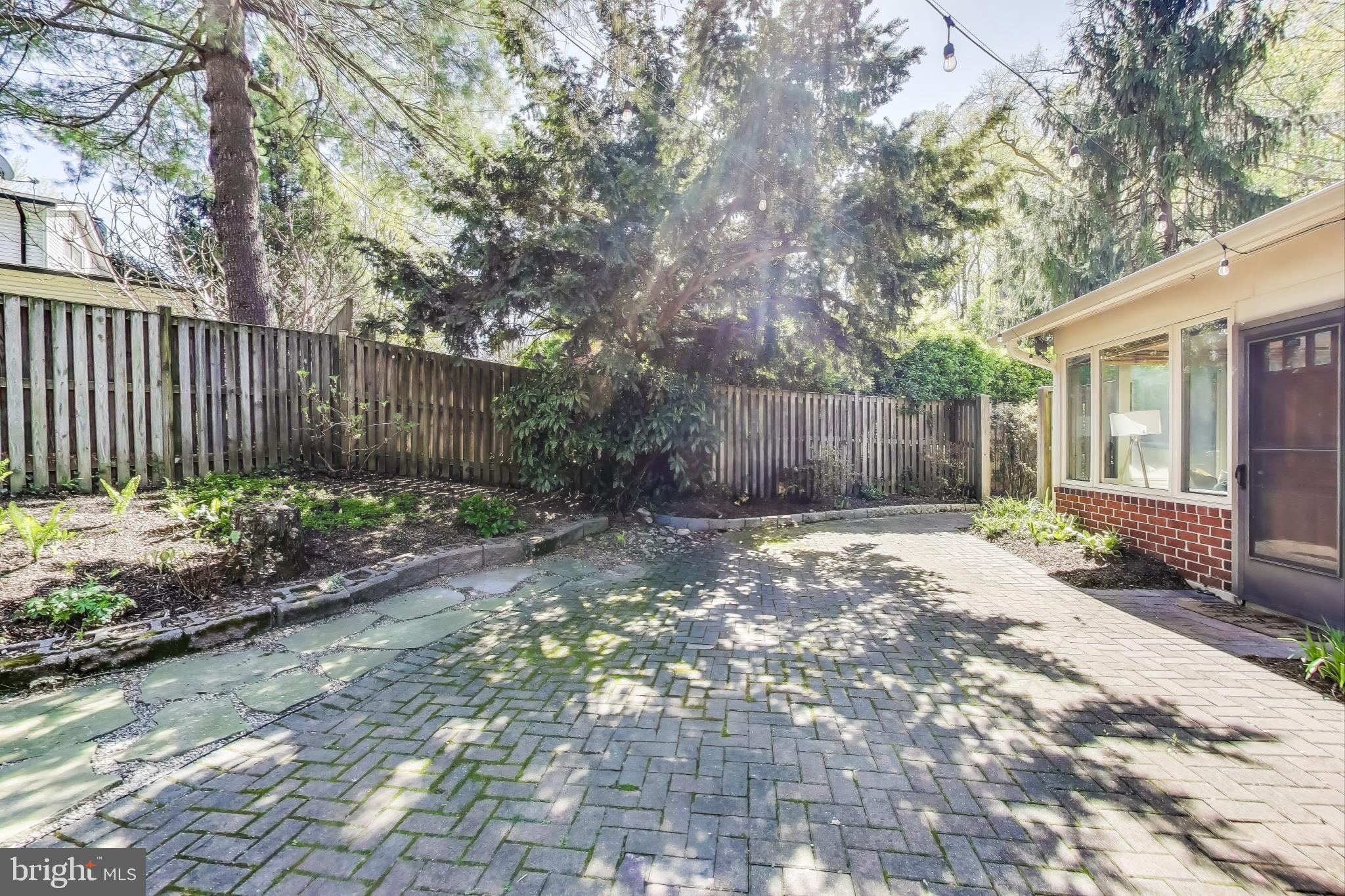 8905 Spring Valley Road Chevy Chase, MD 20815 - Photo 35 of 42 a view of a backyard with large trees and wooden fence