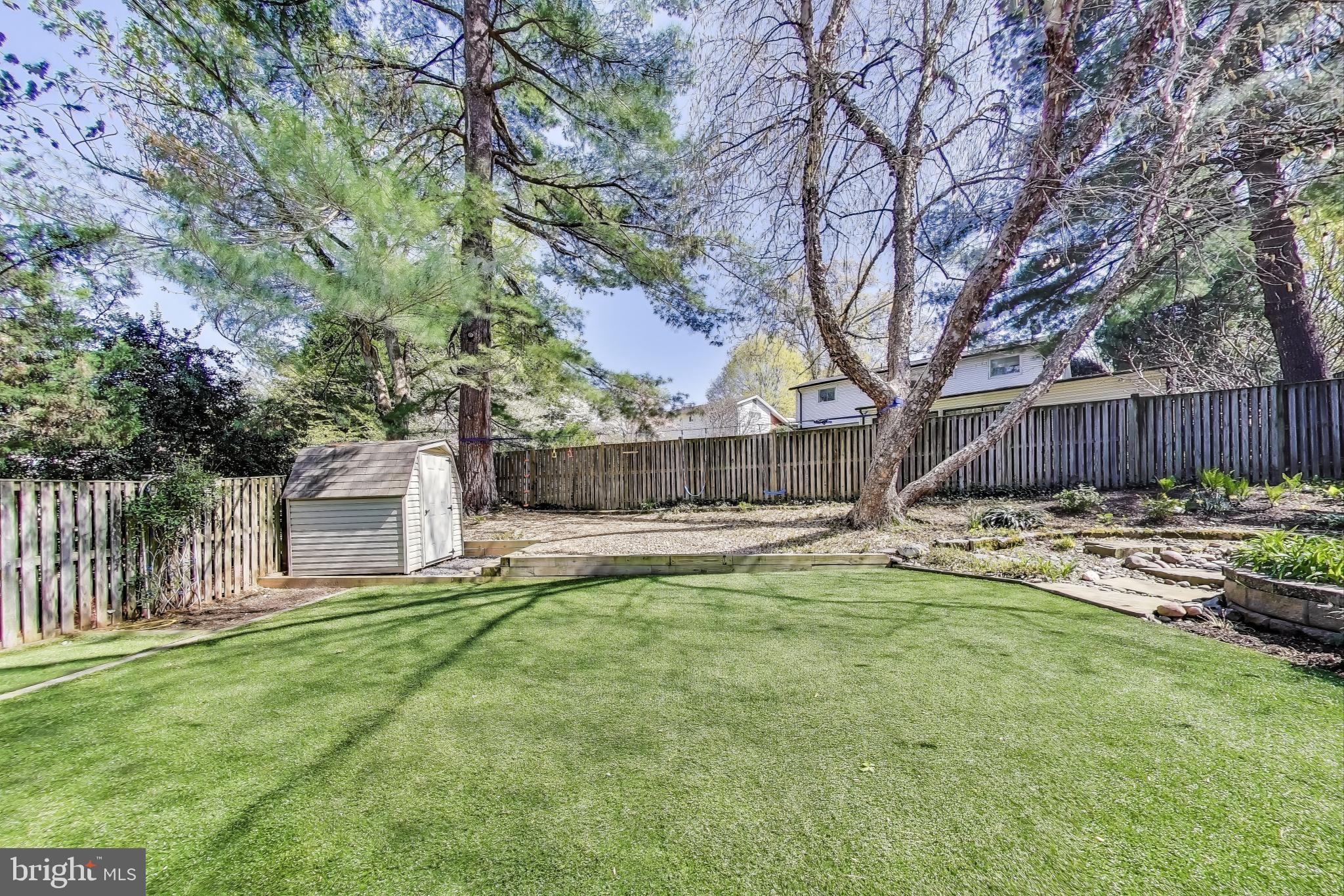 8905 Spring Valley Road Chevy Chase, MD 20815 - Photo 38 of 42 a view of a house with a yard and a tree with wooden fence