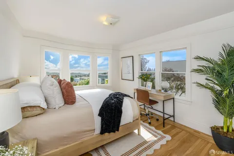 a bedroom with a bed and a potted plant