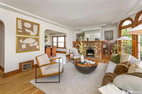 a living room with furniture a fireplace and a large mirror