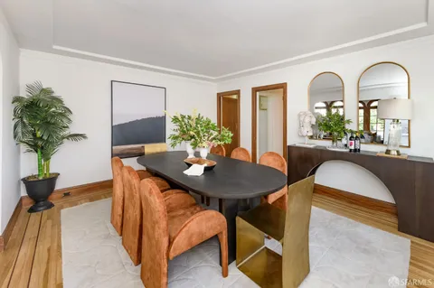 a view of a dining room with furniture and a potted plant