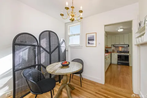 a view of a dining room with furniture a chandelier and wooden floor