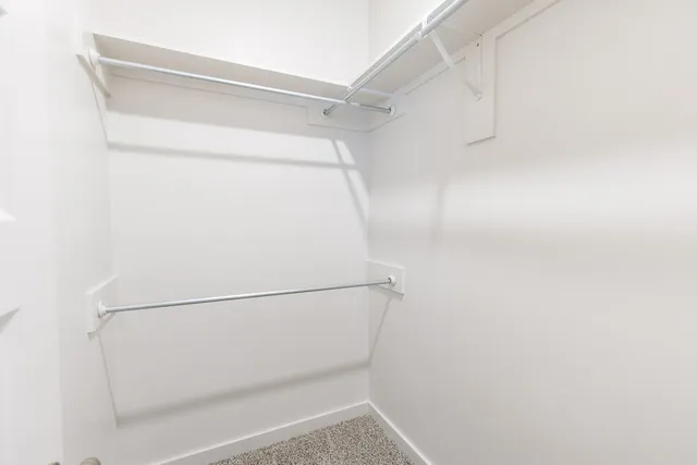 an empty room with a window and a ceiling fan