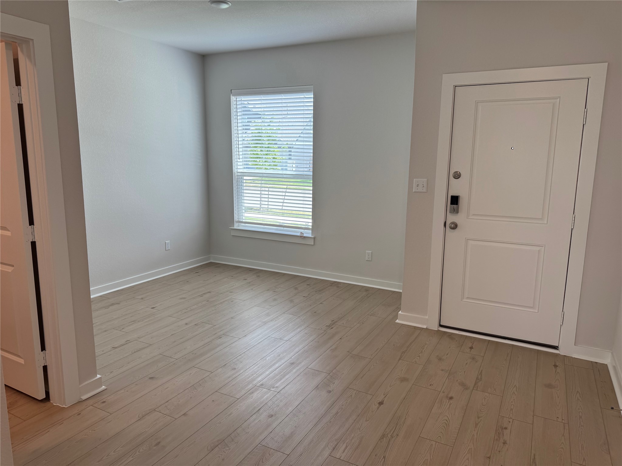109 Corn Lane Hutto, TX 78634 - Photo 3 of 35 an empty room with wooden floor and window
