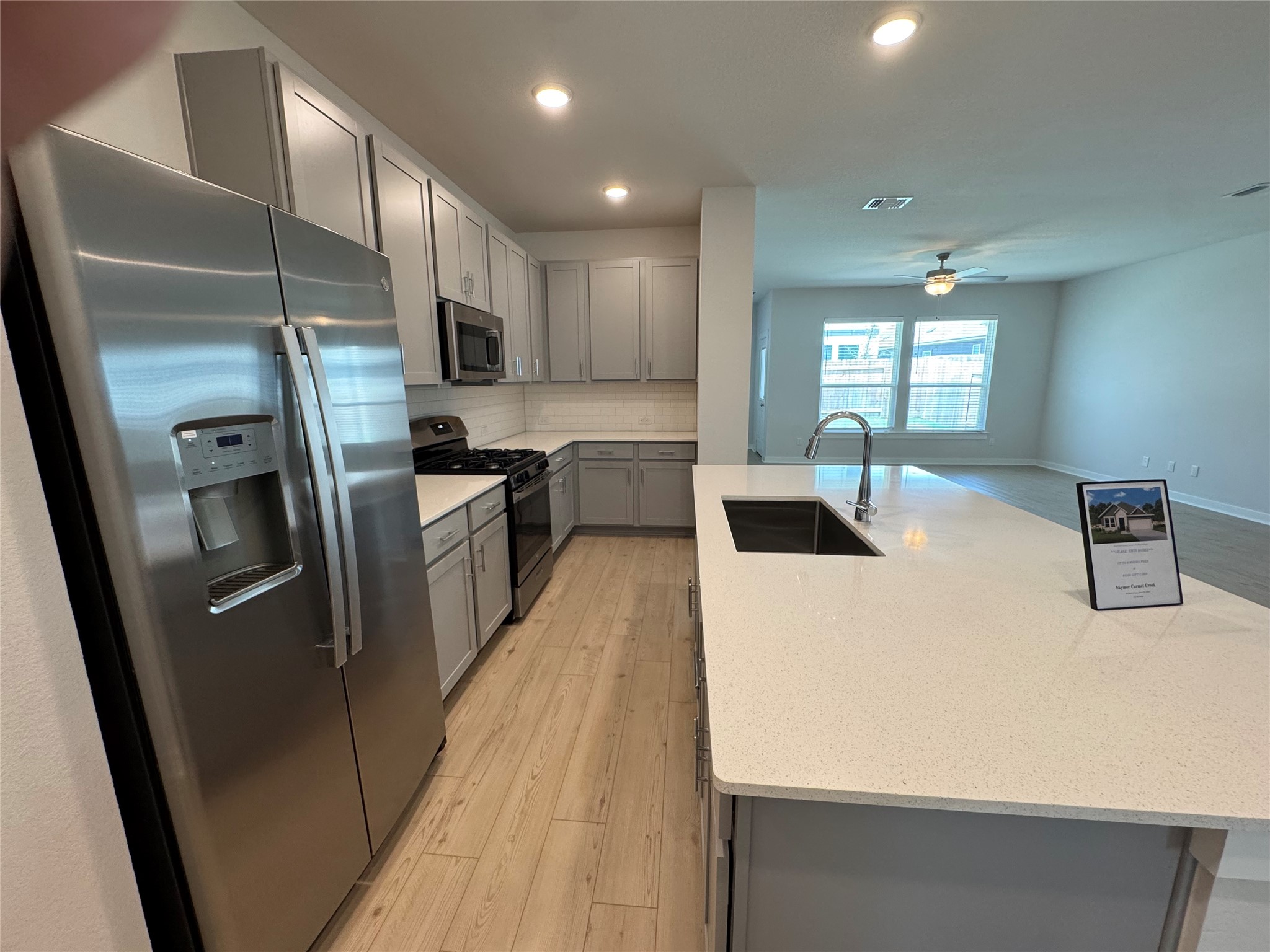 109 Corn Lane Hutto, TX 78634 - Photo 6 of 35 a kitchen with stainless steel appliances a refrigerator a sink a stove top oven a sink with wooden floor