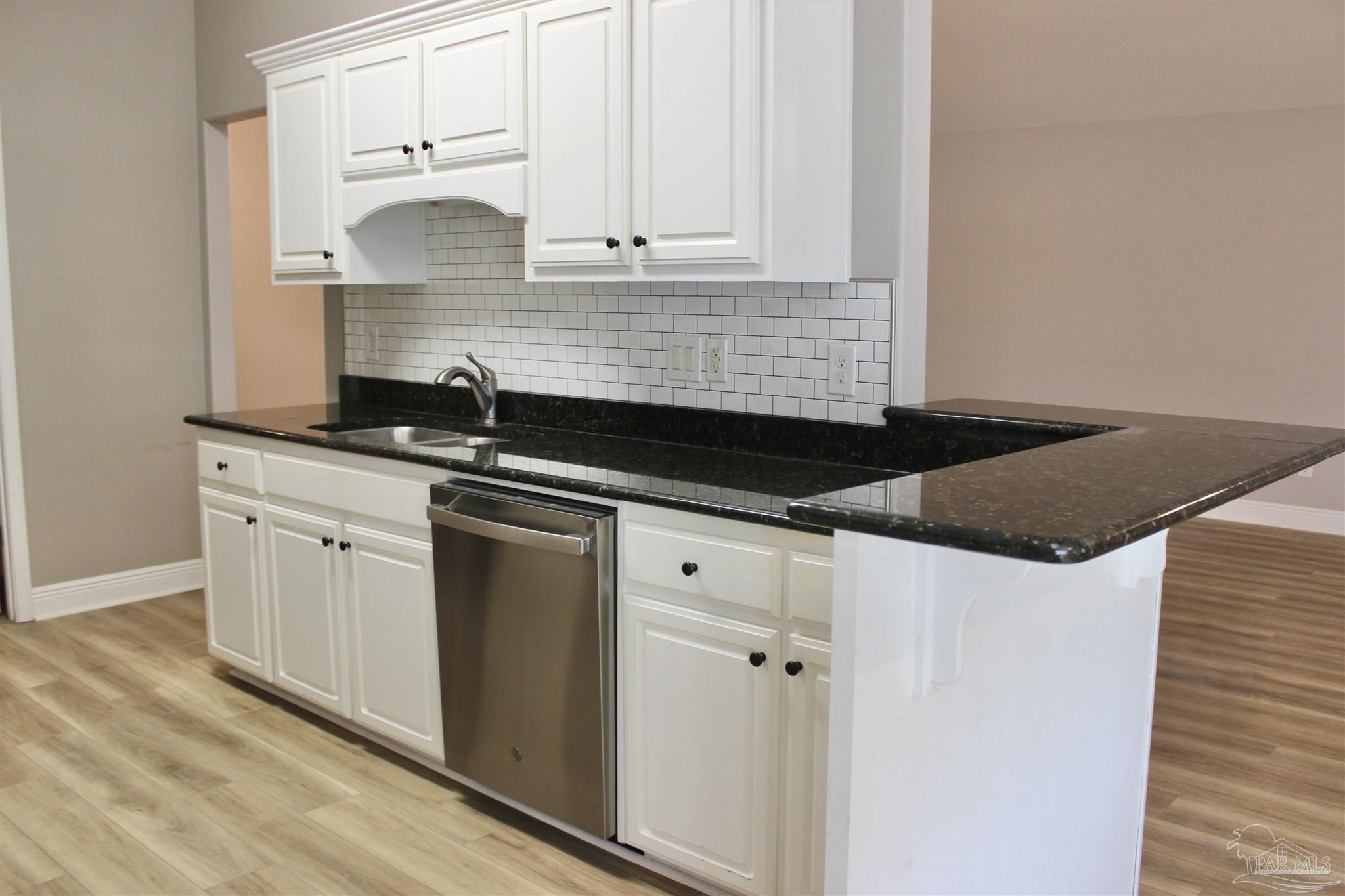 6364 Parakeet Trail Pensacola, FL 32503 - Photo 17 of 72 a kitchen with granite countertop white cabinets and black appliances