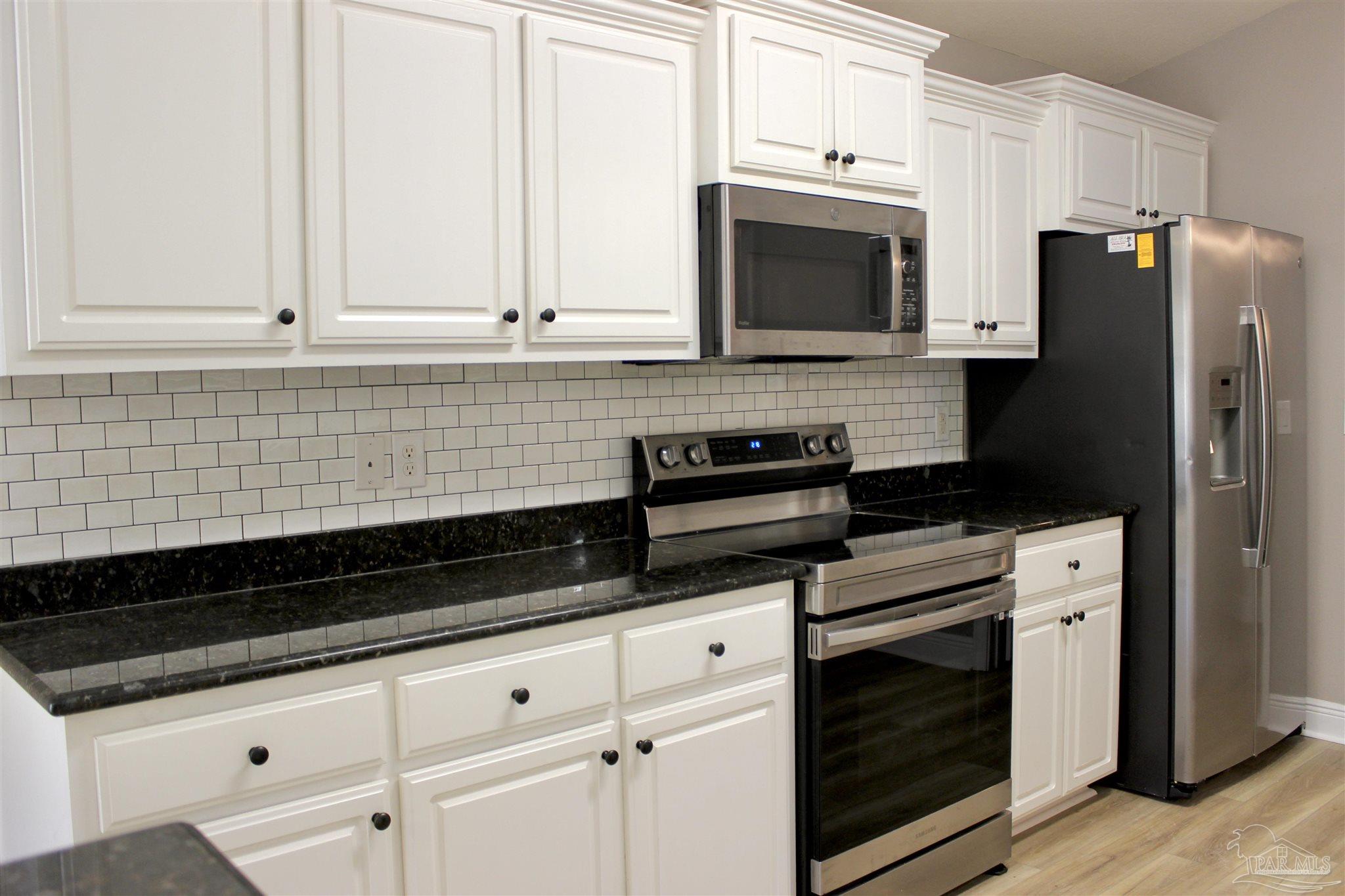 6364 Parakeet Trail Pensacola, FL 32503 - Photo 26 of 72 a kitchen with granite countertop white cabinets stainless steel appliances and sink