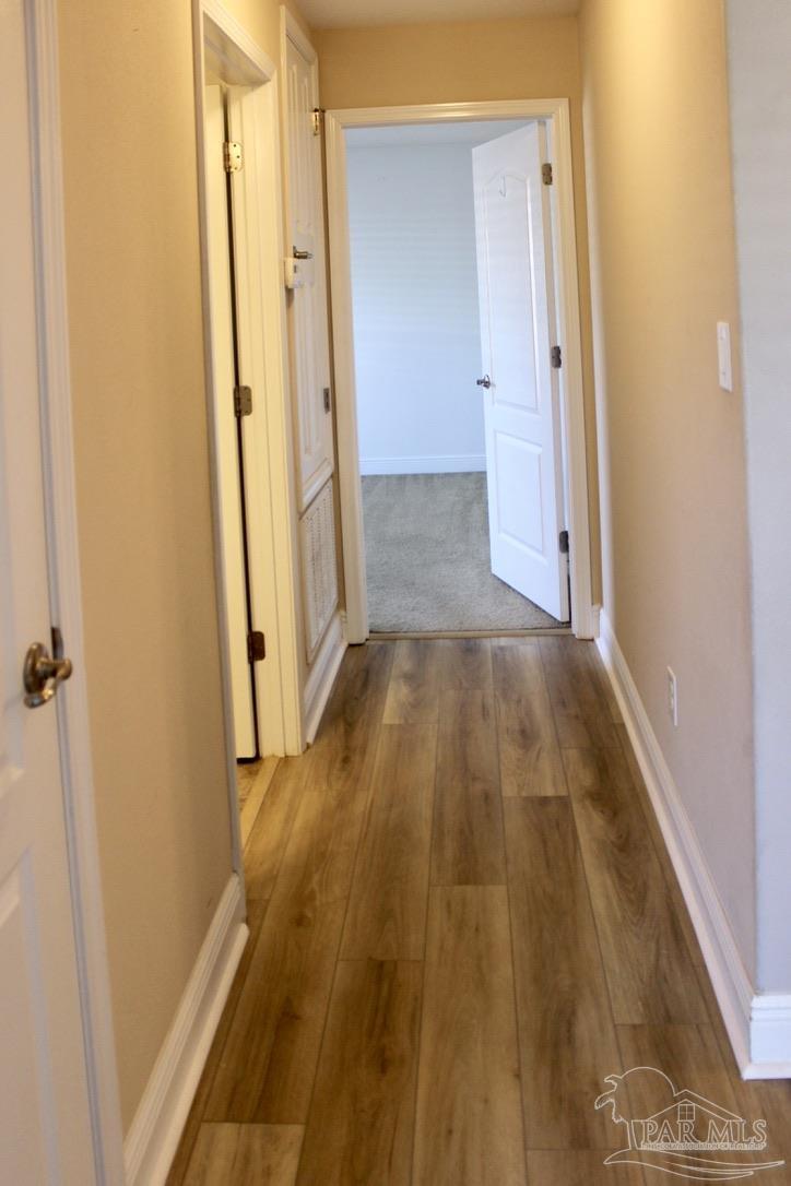 6364 Parakeet Trail Pensacola, FL 32503 - Photo 55 of 72 a view of a hallway with wooden floor and a bathroom