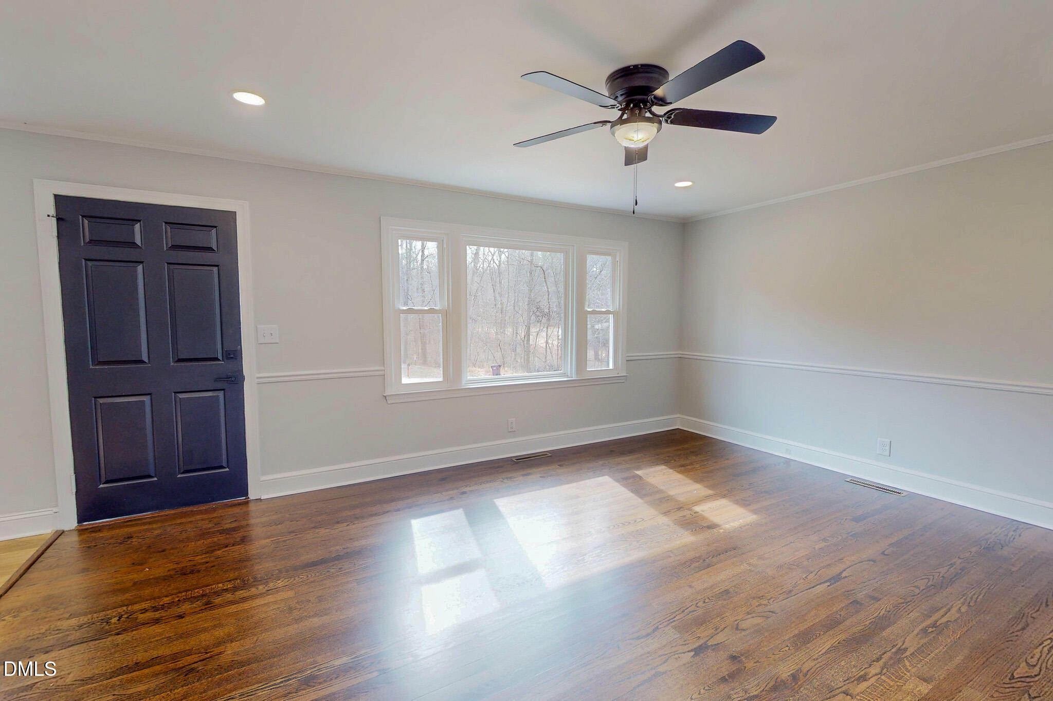 844 Holeman Ashley Road Timberlake, NC 27583 - Photo 2 of 58 an empty room with wooden floor chandelier fan and windows