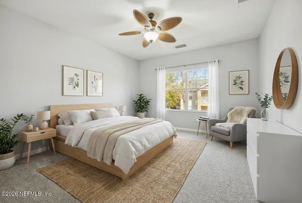 an empty room with chandelier fan and windows