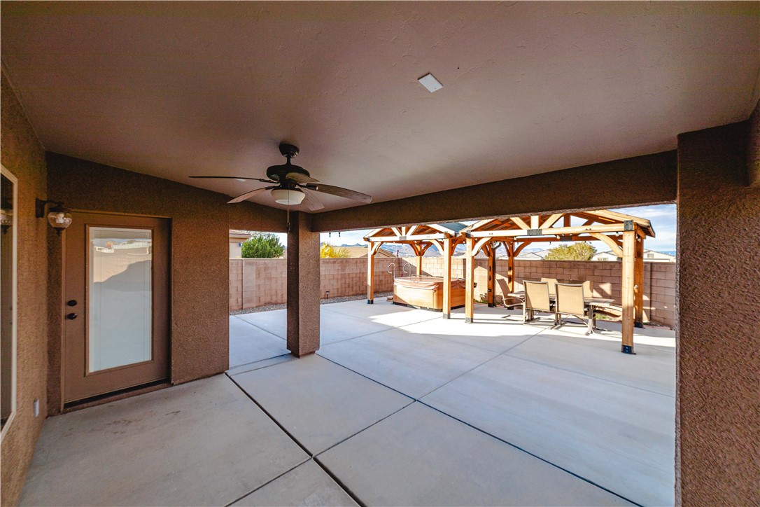 3379 Motherload Road Kingman, AZ 86401 - Photo 12 of 67 Fenced backyard with a patio, a ceiling fan, and a hot tub
