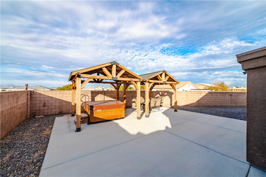 3379 Motherload Road Kingman, AZ 86401 - Photo 14 of 67 Fenced backyard with a hot tub and a patio area